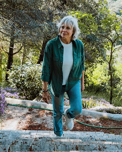 Older adult walking comfortably outdoors after genicular artery embolization knee treatment