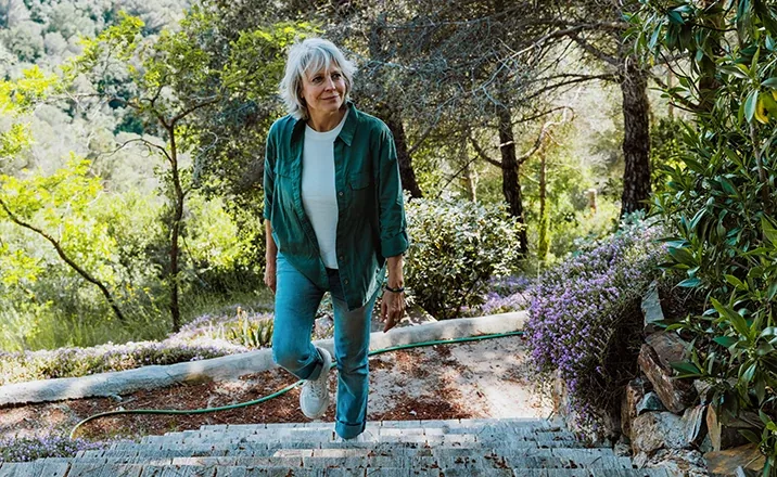 Older adult climbing outdoor steps comfortably after knee arthritis treatment